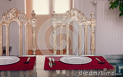 The kitchen table porcelain plates fork , knife , and two vintage chair against the window Stock Photo