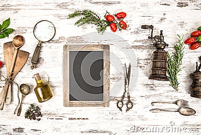 Kitchen utensils with tomatoes, herbs and blackboard Stock Photo