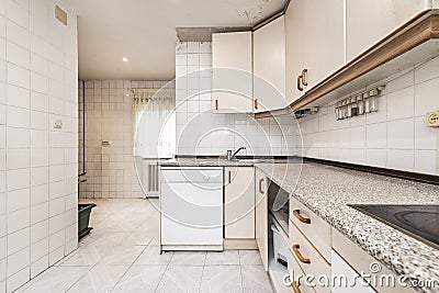 kitchen with white tiles with L-shaped furniture Editorial Stock Photo