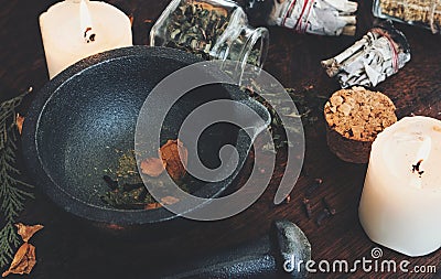 Kitchen witchery - making magickal spice blend for a spell. Dried herbs and spices mixed in mortar Stock Photo