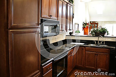 Kitchen wood cabinets black and stainless stove Stock Photo