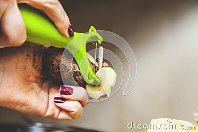 Cleaning potatoes. hands of woman clean potatoes with special t Stock Photo