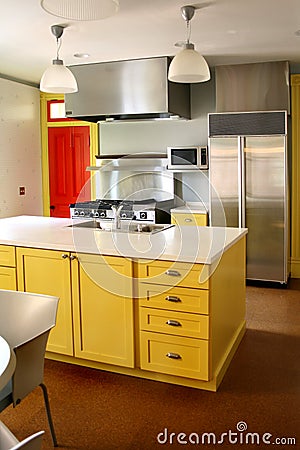 Kitchen yellow wood cabinets stainless stove Stock Photo