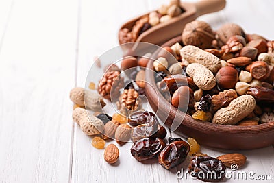 Kitchenware with different nuts and dried fruits on wooden table Stock Photo