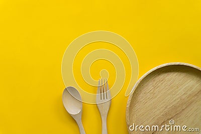 Kitchenware set of wooden spoon and wooden fork isolated with yellow background Stock Photo