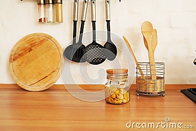 Kitchenware with wooden spoons in vase on wooden table Stock Photo