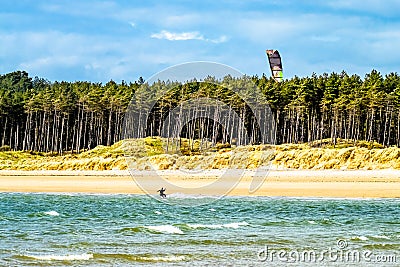 Kite flyer surfing at Newborough beach - Wales - UK Stock Photo