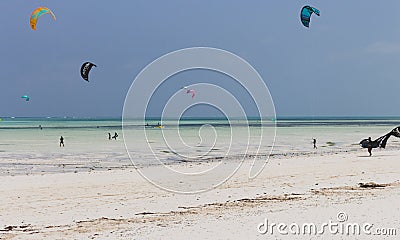 Kite surfing on tropical beach, low tide. Kite surfers on the sea. Scenic Indian Ocean with kite boards, Zanzibar, Paje beach. Editorial Stock Photo