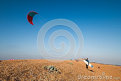 Kiteboarder pulling tricks and getting air on a bright summers day with perfect clear blue sky`s. Shingle Strret, Suffolk, UK Editorial Stock Photo