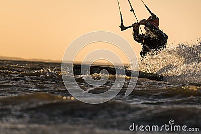 Kitesurfer riding in beautiful yellow sunset conditions Stock Photo