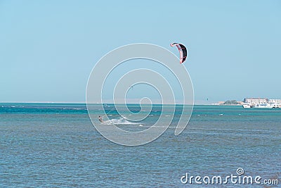 Kitesurfer riding ocean waves on a bright sunny day Editorial Stock Photo