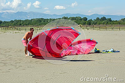 Kitesurfers on the beach prepare sport equipment for riding Stock Photo