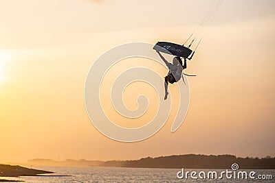 kitesurfing. A surfer rides on a beautiful backdrop of bridges and coastline at sunset and performs all kinds of stunts Editorial Stock Photo
