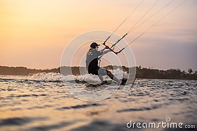 kitesurfing. A surfer rides on a beautiful backdrop of bridges and coastline at sunset and performs all kinds of stunts Editorial Stock Photo
