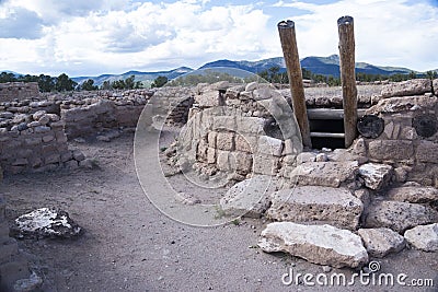 Kiva entrance and traditional wooden ladder to descend down into the round room at the Puye Cliff Dwellings Stock Photo