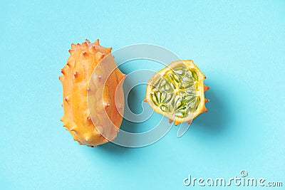 Kiwano or african horned melon on blue background. Top view. Cutted hedged gourd, african horned cucumber, english tomato. Exotic Stock Photo