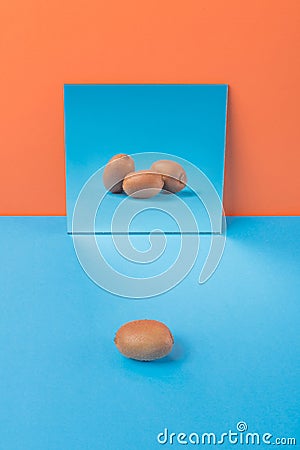 Kiwi on blue table over orange background Stock Photo