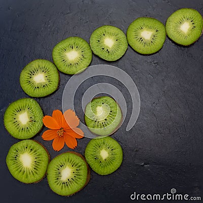 Kiwi fruits were cut into circles and laid out on a black stone tile Stock Photo