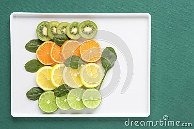 Kiwi, Orange, Lemon and Lime Slices with Spinach Leaves Stock Photo