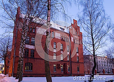 Klaipeda, Lithuania - 01 15 21: Old historical Neo-Gothic University building campus in winter snow, pink sunset colors and city Editorial Stock Photo