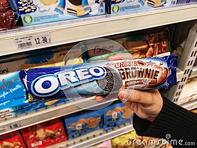 Klang,Malaysia - 30 October 2021 : Hand hold a packed of OREO Choco Brownie Sandwich Cookies Flavour for sell in the supermarket. Editorial Stock Photo