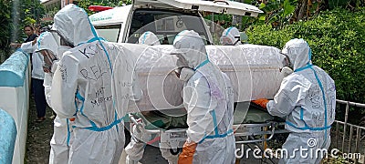 klaten, Indonesia January-20 , 2022 : health workers dressed in PPE suits carry a covered body of a victim who died from covid-19 Editorial Stock Photo