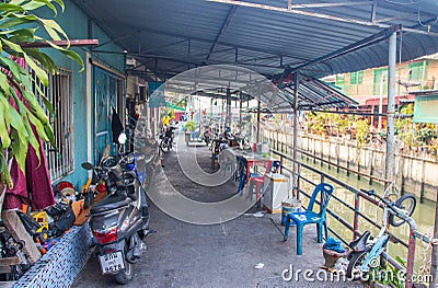 A klong or river channel with fishing boats, buildings and house fronts in Thailand Editorial Stock Photo