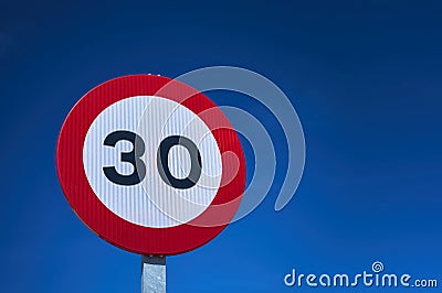 30 kmh mph speed limit traffic sign over a blue sky Stock Photo