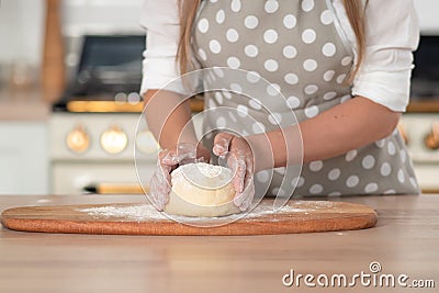 Knead dough, hand dough and flour close-up. A pastry chef in a grey polka-dot apron. Stock Photo