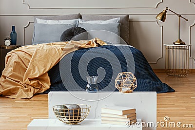 Knick knacks on console table in from of king size bed with comfortable bedding Stock Photo