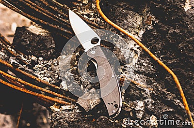 Knife for city carrying. Knife with a hole in the blade. Horizontal frame.. Urban style. Stock Photo