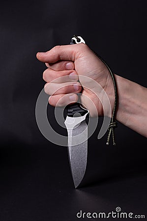 The knife is clenched in the hand. The hand is clenched into a fist Stock Photo