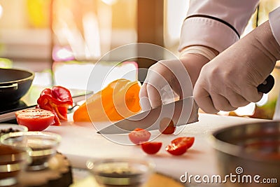 Knife cuts small tomato. Stock Photo