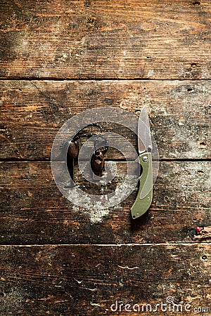 Knife and flint. Tourist folding knife and steel for kindling the fire. Travel items on an old wooden table. Stock Photo