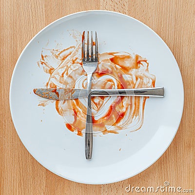 Knife and fork crossed in finish plate and heart shape ketchup, Stock Photo