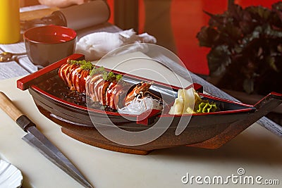Knife lying near sushi boat. Stock Photo