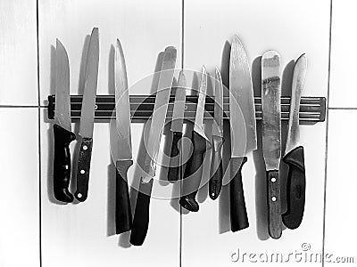 Knife magnet on the wall, many different knives; vintage, grunge, black and white concept Stock Photo