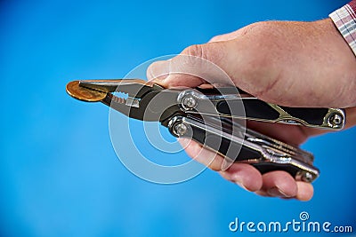 Metal knife multitool turned into pliers in the hands of a man Stock Photo