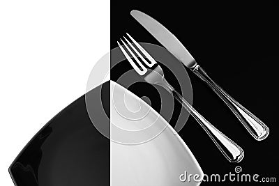Knife, square white plate, fork on black top view Stock Photo