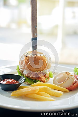 Knife stabbed on fried chicken hamburger Stock Photo