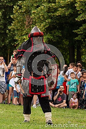 Valiant Knight in Armor Wields Mace and Shield: Epic Battle Reconstruction at the International Knights Festival Editorial Stock Photo