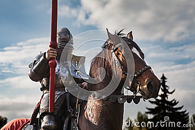 Knight on horseback. Horse in armor with knight holding lance. Horses on the medieval battlefield. Stock Photo