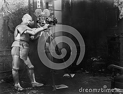 Knight at the movies, a man in an armored suit uses a film camera Stock Photo
