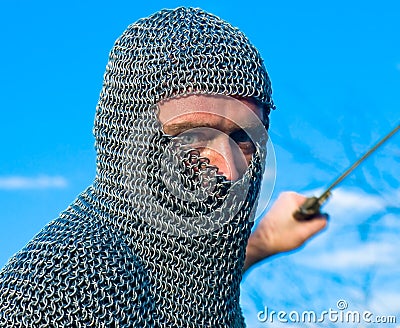 Knight wearing armour and hold on a sword Stock Photo