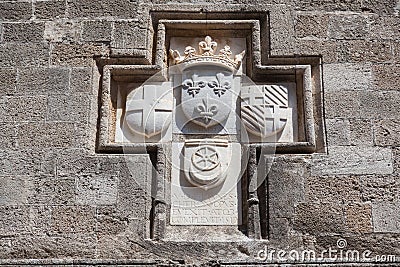 Knightly coat of arms on the wall of a house in Rhodes. Stock Photo