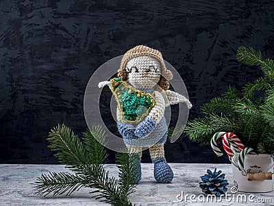 Knitted angel with capacious and sweets , fir branches Stock Photo