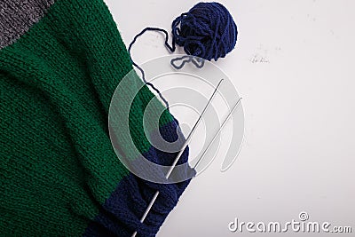 Knitted clothing, accessory in process of making. Knitting needles and ball of threads, yarn on white background. Striped blue, Stock Photo