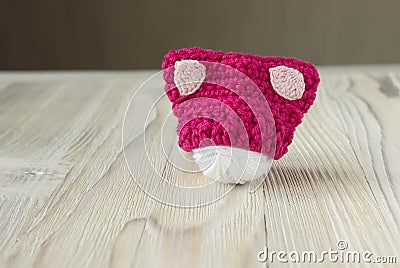 Knitted crochet small pink hat. Women`s hat for feminists march protest. Creative craft work Stock Photo