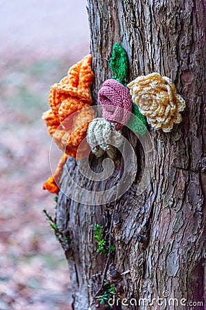 Knitted Flower on tree bark Stock Photo