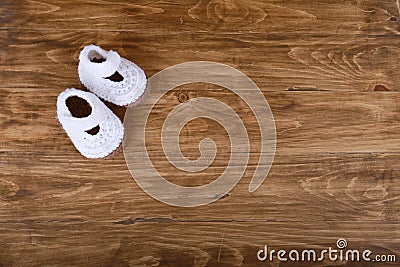 Knitted handmade baby shoes on wood background Stock Photo